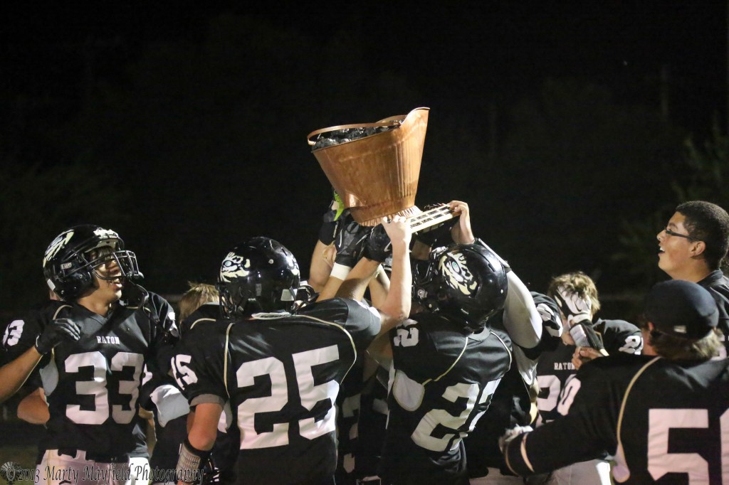 Held up high the Tigers celebrate their nail biter win with the coal bucket.