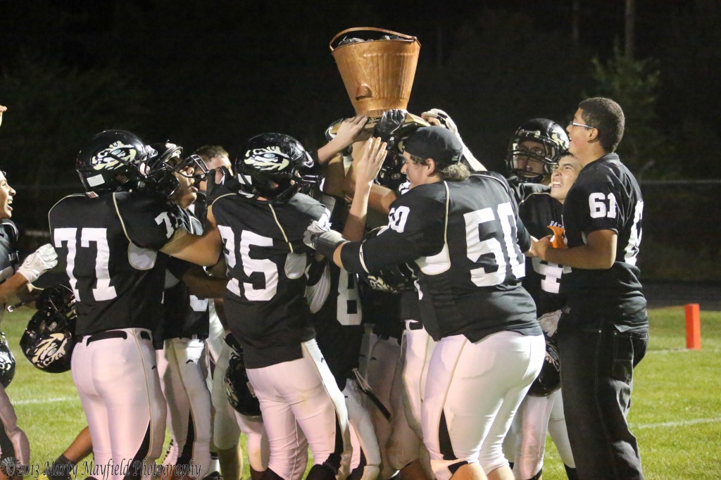 The Tigers celebrate the win with the Coal Bucket Friday night in the Jungle
