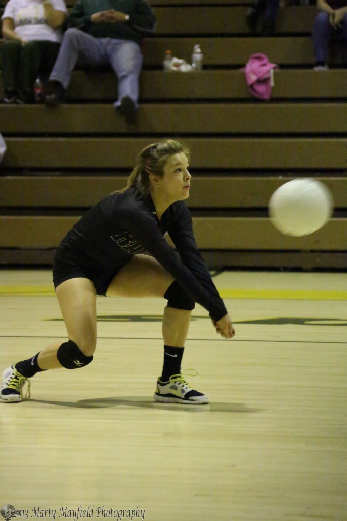 Senior Ila Medina gets down to setup the pass during the fourth game of the district match in Las Vegas Friday night