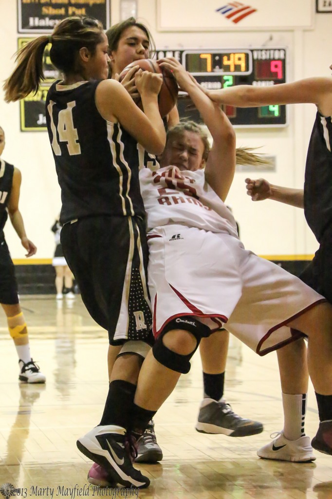 Briana Pais (14) and Tarryn Trujillo team up against Jessica Pitman in a struggle for the ball Friday night during the 77th Annual Cowbell Tourney