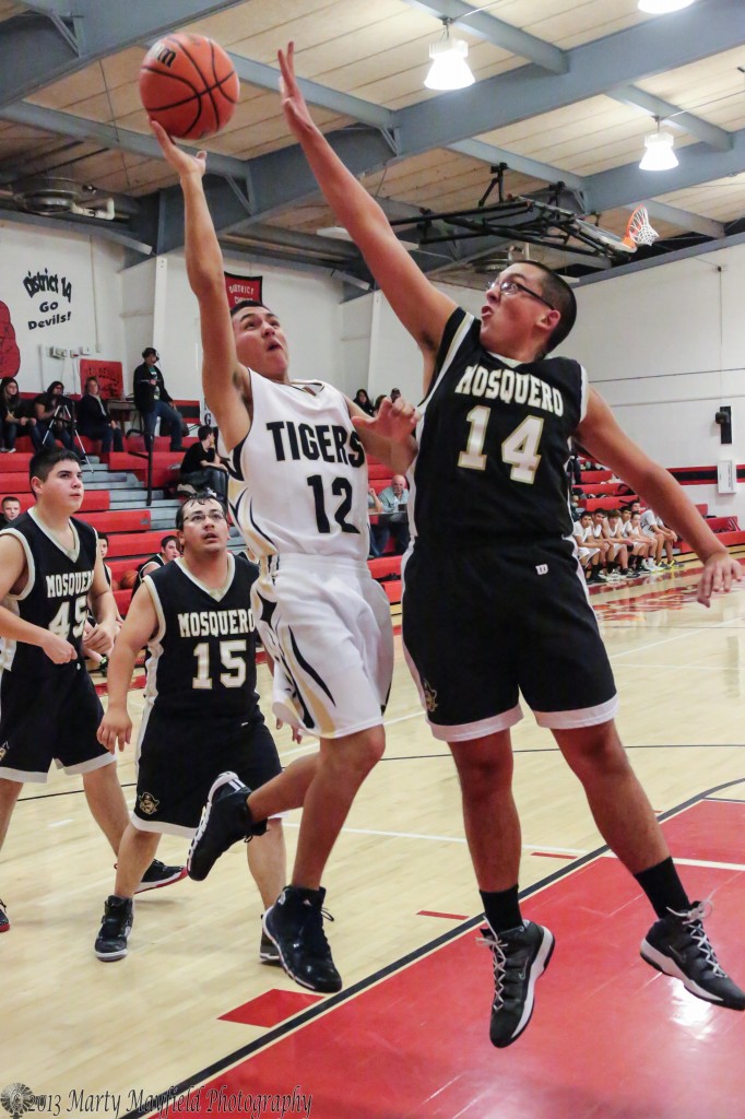 Gus Thrasher goes for the block as Jodus Gonzales goes for the layup during the 77th Annual Cowbell 