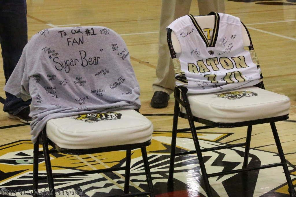 Two empty chairs with a T-shirt and Jersey sit at center court in Tiger Gym in honor of Henry "Sugar Bear" Tapia. 