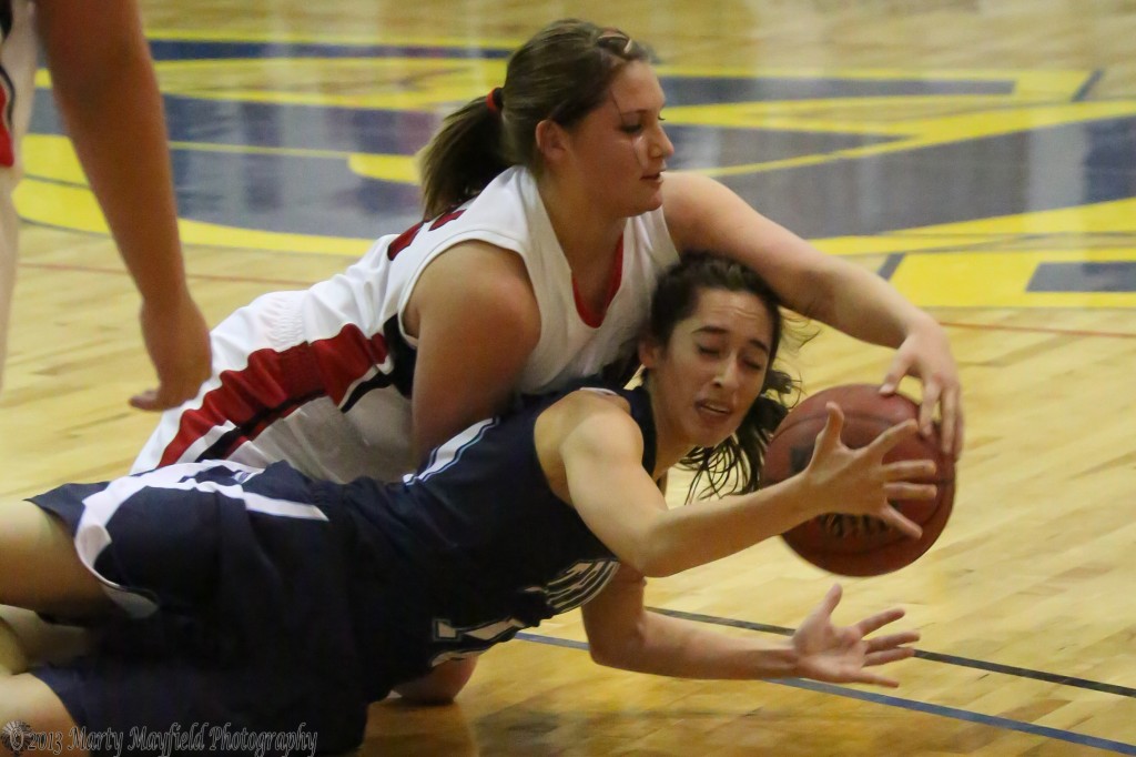 Trinidad's Cameron Gomez and Springer's Kyra Laumbach scramble for the ball during the girl's championship game Saturday evening in Scott Gym