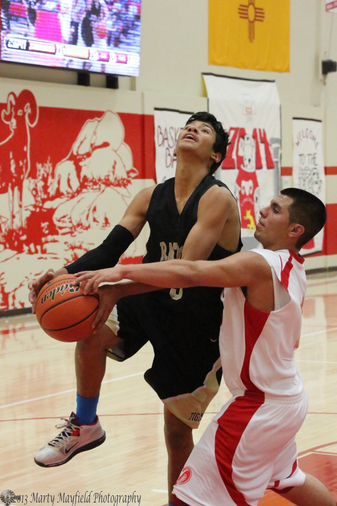 Jonathan Cabrielas draws the foul from Frank Cortez as he heads for the basket saturday evening in Cimarron.