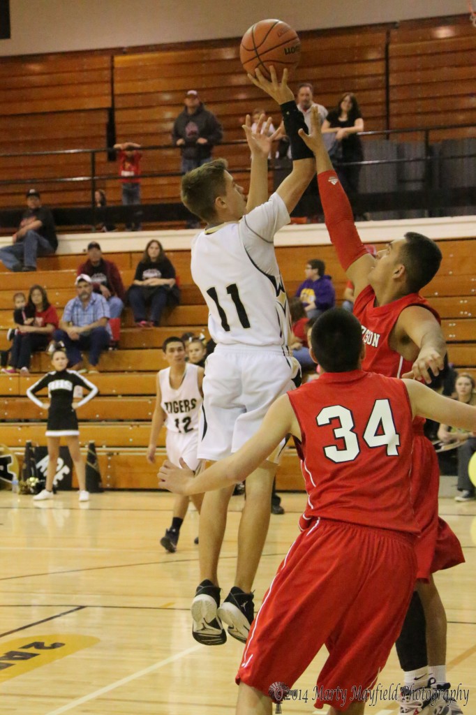 Kevin Fanelli puts up the short jumper as Richardo Martinez goes for the block in the varsity game with Robertson. 