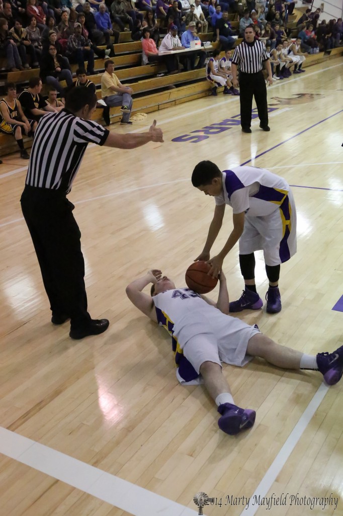 Tyler Hightower finds himself on the floor after a tangle for a jump ball as indicated by the referee Thursday night in Maxwell during the District 1B tourney.