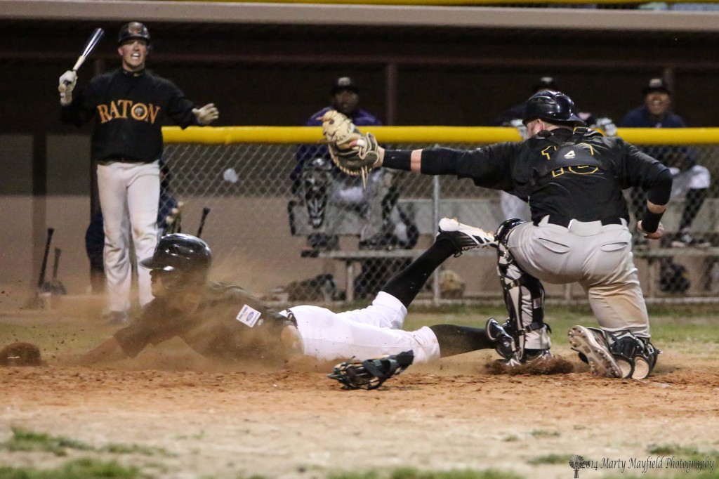 Safe at home plate as the base runner slide in under the catchers mitt.