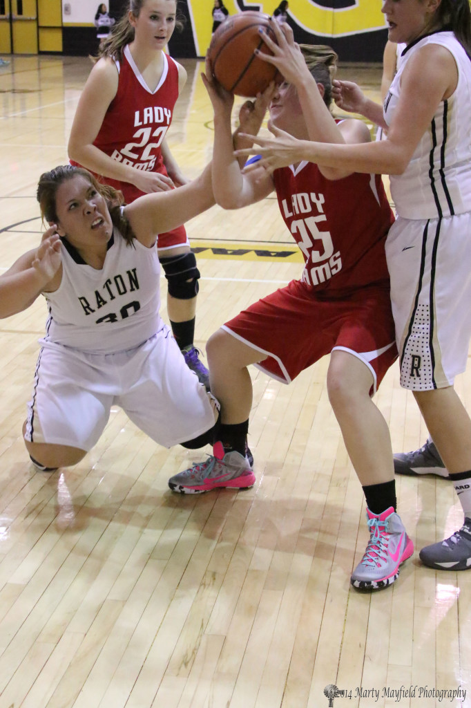 Raton's Sydni Silva and Lady Ram Jessica Pittman tangle for the ball during the varsity game in Raton Thursday evening 