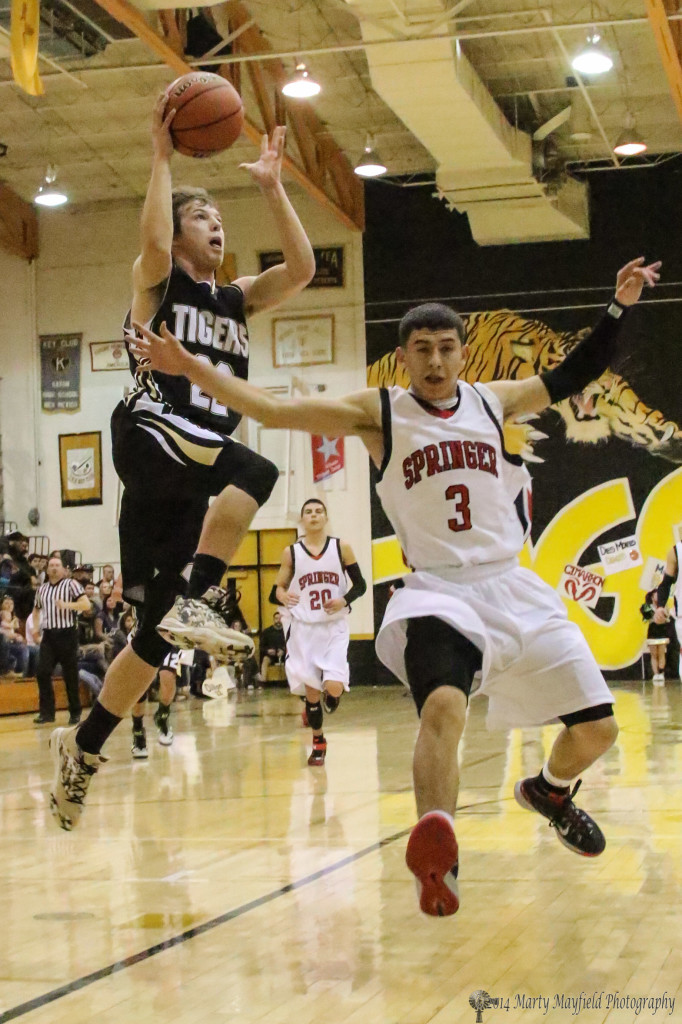 Dillon Lemons flies in behind Uriel Urquijo (3) on his way to the basket Friday night during the 78th Annual Cowbell tourney in Raton.