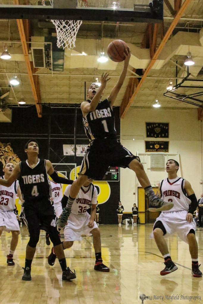 Jesse Espinoza Flies high for the lay-up as several of the players look on during the Springer Raton game Friday night. 
