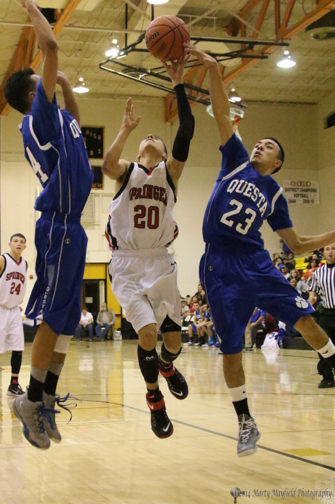 Anthony Romero (20) heads into the basket as Zack Gallegos gets a finger on the ball and Zack Gallegos is set for the block during the championship game of the 78th Annual Cowbell Tourney