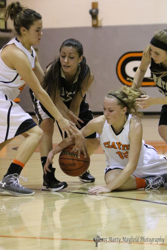 Mason Crisp (15) and Bri Fong tangle with Daisy Earle for the ball during the JV game in Clayton Saturday night 