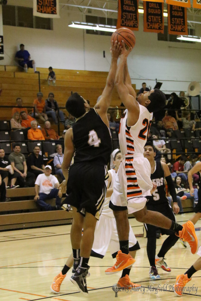 Jonathan Cabrieles (4) gets a hand on the ball as Irving Tarin (20) goes up for the shot Saturday evening in Yellowjacket Gym