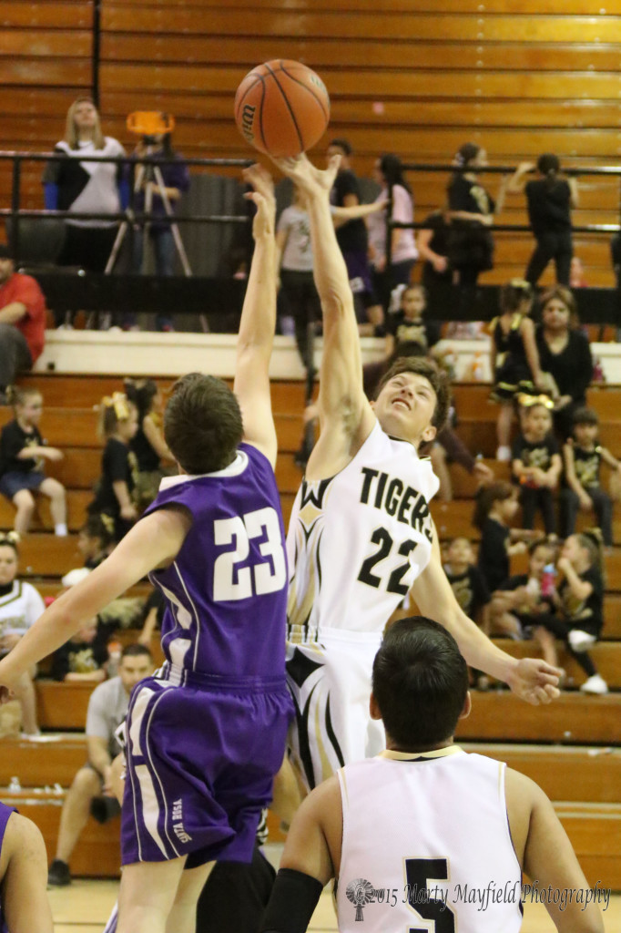 Dillon Lemons (22) wins the jump ball against Pryce Marez (23) as the boys begin the game Friday night.