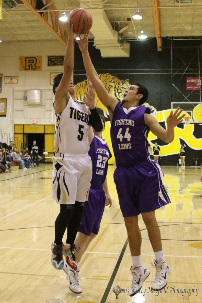 Jacob Sanchez (44) get a hand on the ball as Austin Jones goes up for the shot. 
