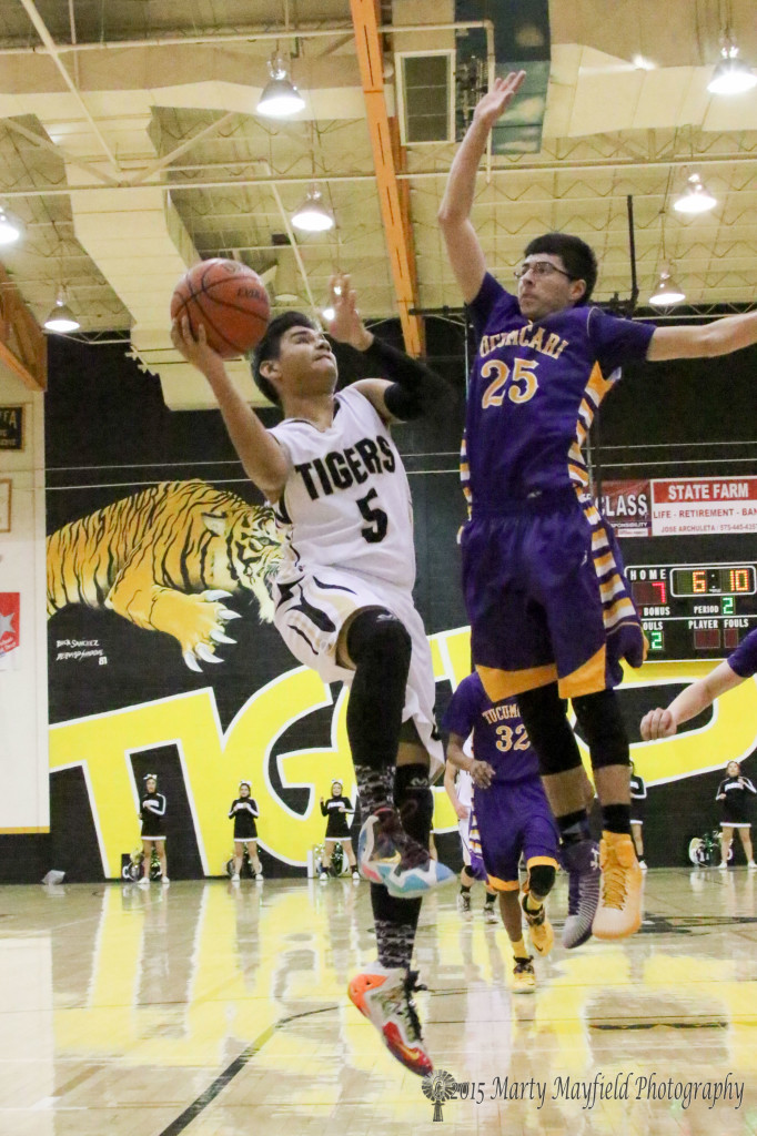 Austin Jones (5) goes for the basket as John Paul Garcia (25) goes for the block Saturday night in tiger Gym