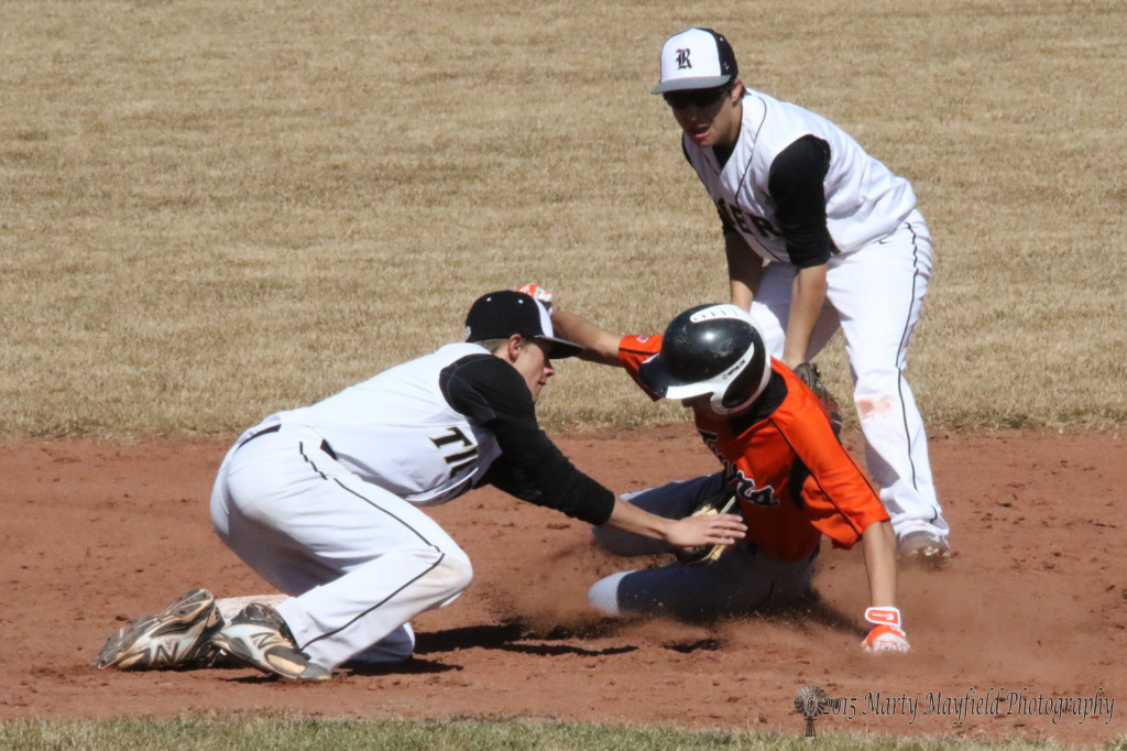 Shortstop Ethan Washburn catches the Taos player at second for the out as Brandon Luksich watches 