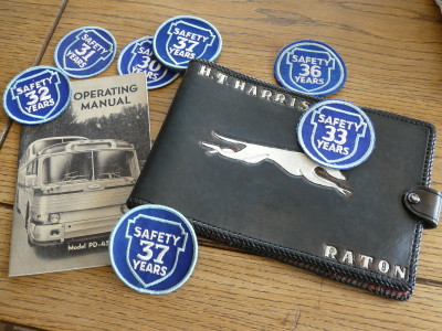 These patches represent a sampling of the many safety awards  earned by Charles Unger for his excellent driving record. Also shown are Harold Harris' log book and operator's manual.