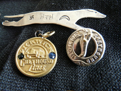 The Greyhound pin is stamped with a Swastika, which was considered a symbol of good luck in pre-World War II days, and the initials HTH (Harold T. Harris). The other items shown are a Pickwick-Greyhound pendant and a Greyhound Motor Transit button.