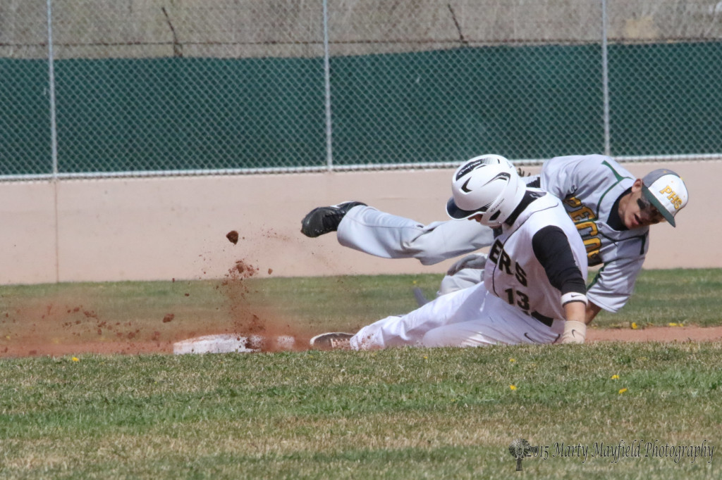 Martin Ortiz (13) slides in to second and gets tagged by Mario Archuleta for an out.