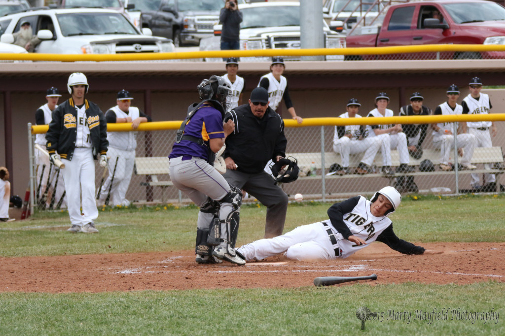 Brandon Luksich slides home and safer as he beats the throw home as Raton continues its five run rally