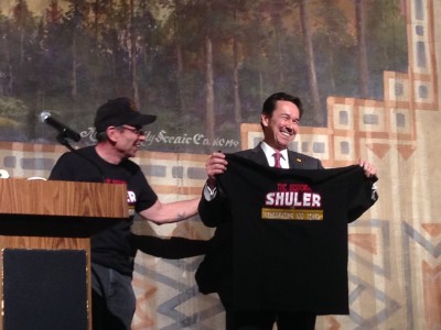 Billy Donati of the Shuler Restoration Board gives a Shuler 100th Anniversary t-shirt to Cabinet Secretary Jon Barela.