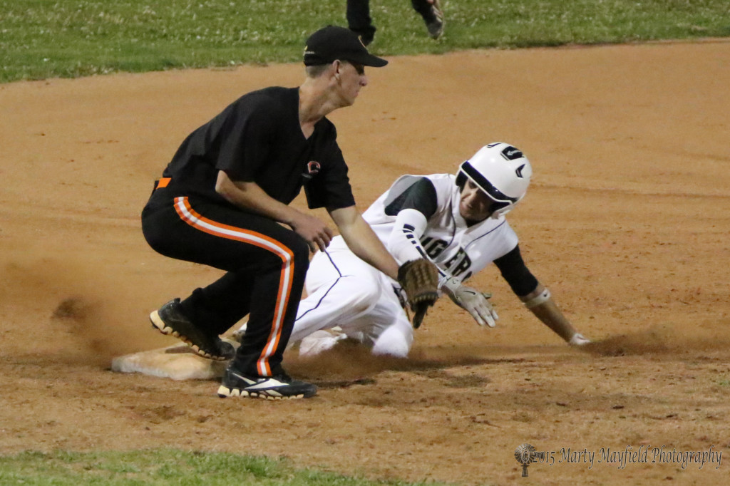 Martin Ortiz slides into third ahead of the ball to Carson Vandiver