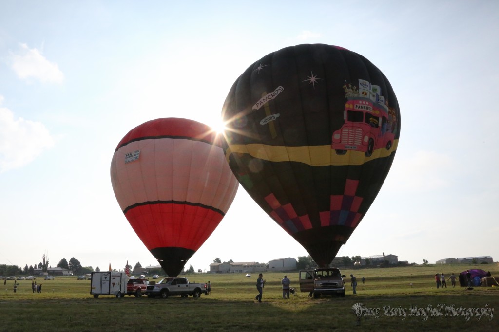 Road Trip and Sun Cahser dance in the light breeze Friday morning as the 2015 International Santa Fe Trail Balloon Rally got underway 