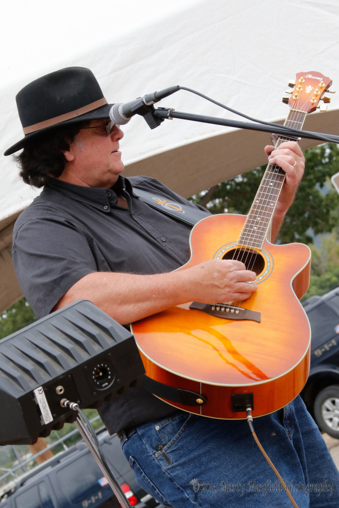 Rick Trice tickles the strings as he performs Sunday afternoon on First Street during the Gate City Music Festival