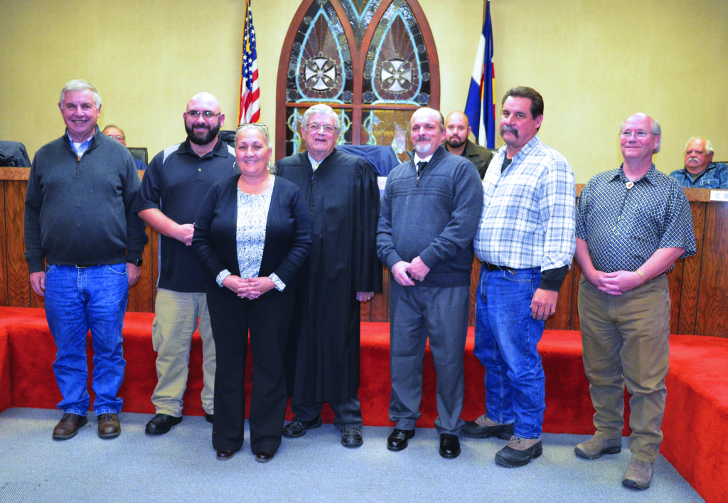 New Walsenburg city council, from left to right: Dennis Hoyt, John Salazar II, City Clerk Wanda Britt, Judge Gary Stork, who swore the new council in, Greg Daniels, Mayor James Eccher, and Treasurer James Moore. In the background are Charles Montoya, Craig Lessar and Clint Boehler.  Photo by Eric Mullens 