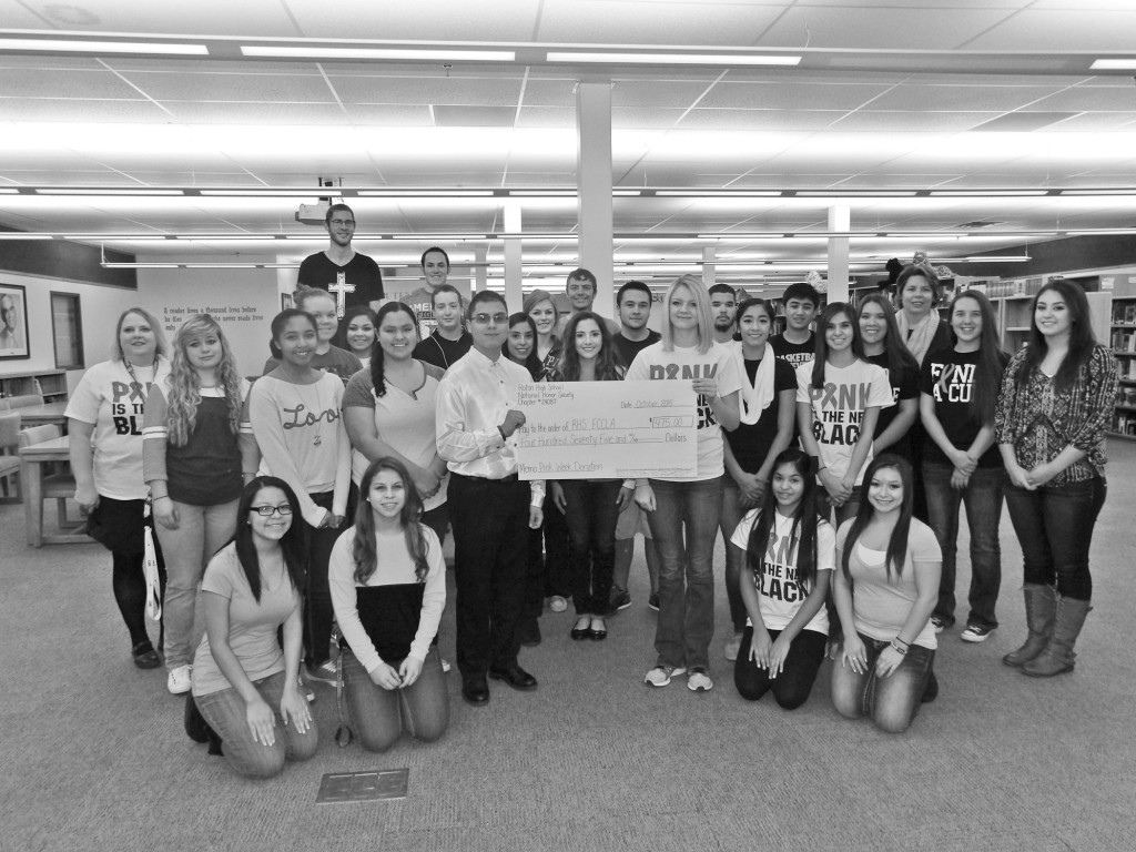 RHS NHS Chapter President Juan Prieto-Archuleta (left of check) presents their check for $475 to RHS FCCLA President Ivy Fernandes (right of check).  They are flanked by members of NHS and FCCLA.  Photo by Colette M. Armijo.