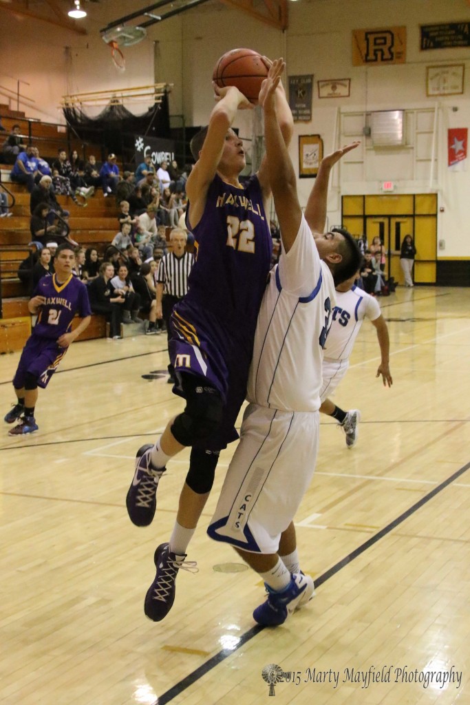 Wildcat David Trujillo goes for the block as Kolten Riggs takes the shot from just outside the lane Friday night at the 79th annual cowbell