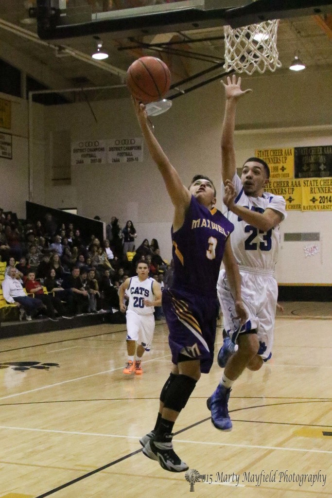 Jeremy Archuleta (3) takes it to the basket as Zack Gallegos reaches for ball Friday evening in Tiger Gym at the 79th annual Cowbell Tourney