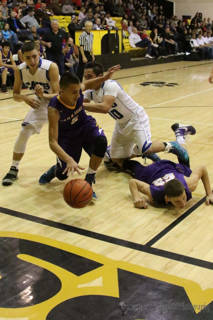 Carl Gonzales tries to maintain balance as Tobias Ortega gets a hand on him to assist his out of bounds progress while Kolten Riggs finds himself on the floor as a stumbling block at the 79th annual Cowbell 