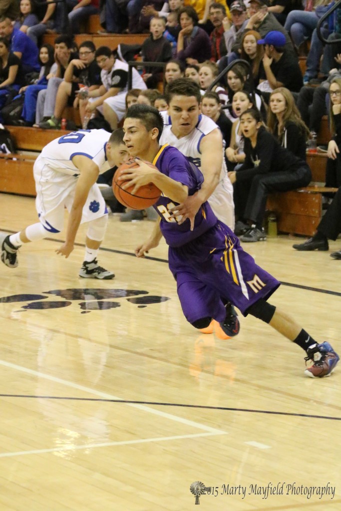 Kevin Ortega reaches around Jeremiah Atencio as he heads toward the basket Friday night in Tiger Gym at the 2015 Cowbell 