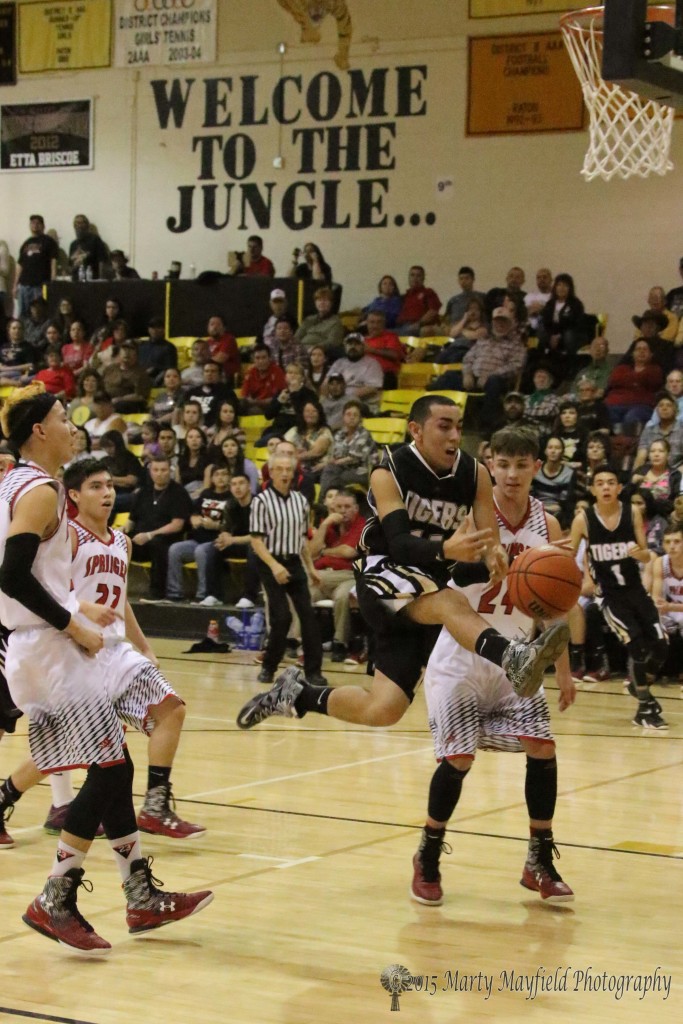 Birthday boy Dustin Segura looses the handle on the ball as he heads for the basket during the game with Springer Friday night at the Cowbell Tourney