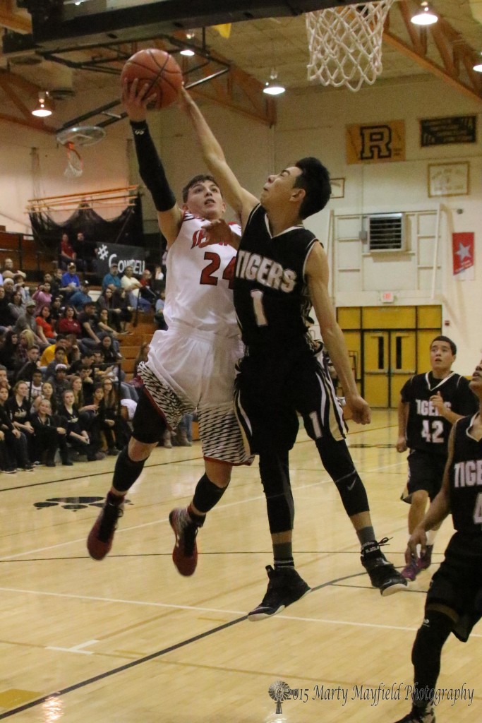 Isaiah Garcia goes for the basket while Jesse Espinoza reaches in for the block during the 2015 Cowbell Tourney in Raton