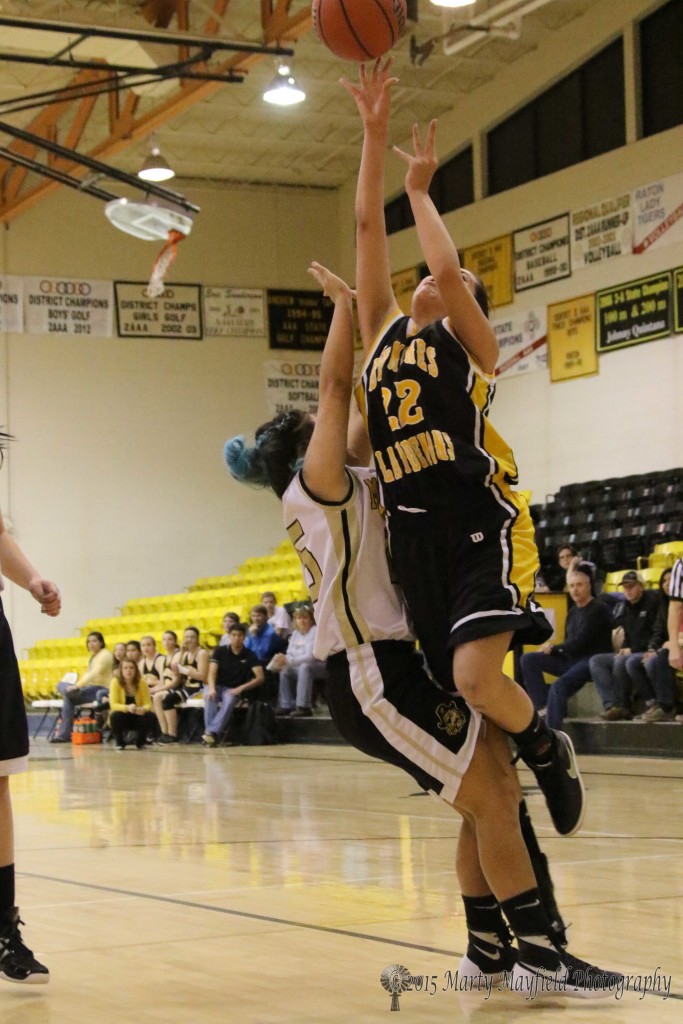 Alexis Wingo goes for the basket as Kasandra Velarde attempts the block Saturday morning at the 2015 Cowbell tourney