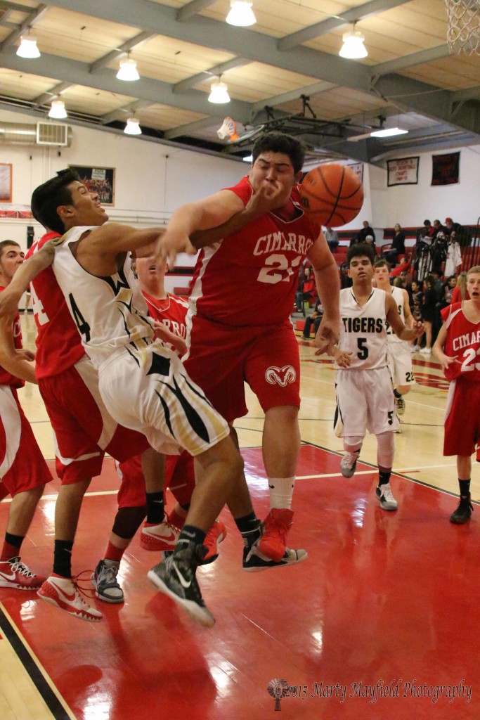 Ram Joseph Serna and Tiger Jonathan Cabreiles collide on the way to the basket Tuesday evening in Springer at the 2015 Cowbell Tourney