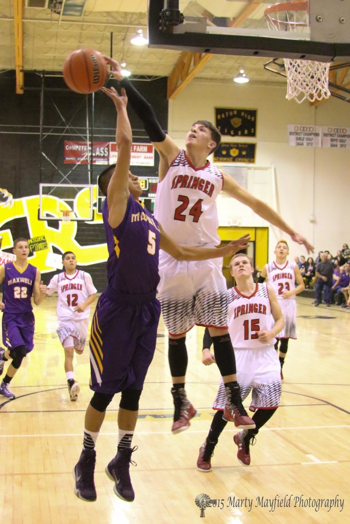 Isaiah Garcia gets a hand on the ball as Carl Gonzales goes up for the lay-up Monday evening in the championship game 