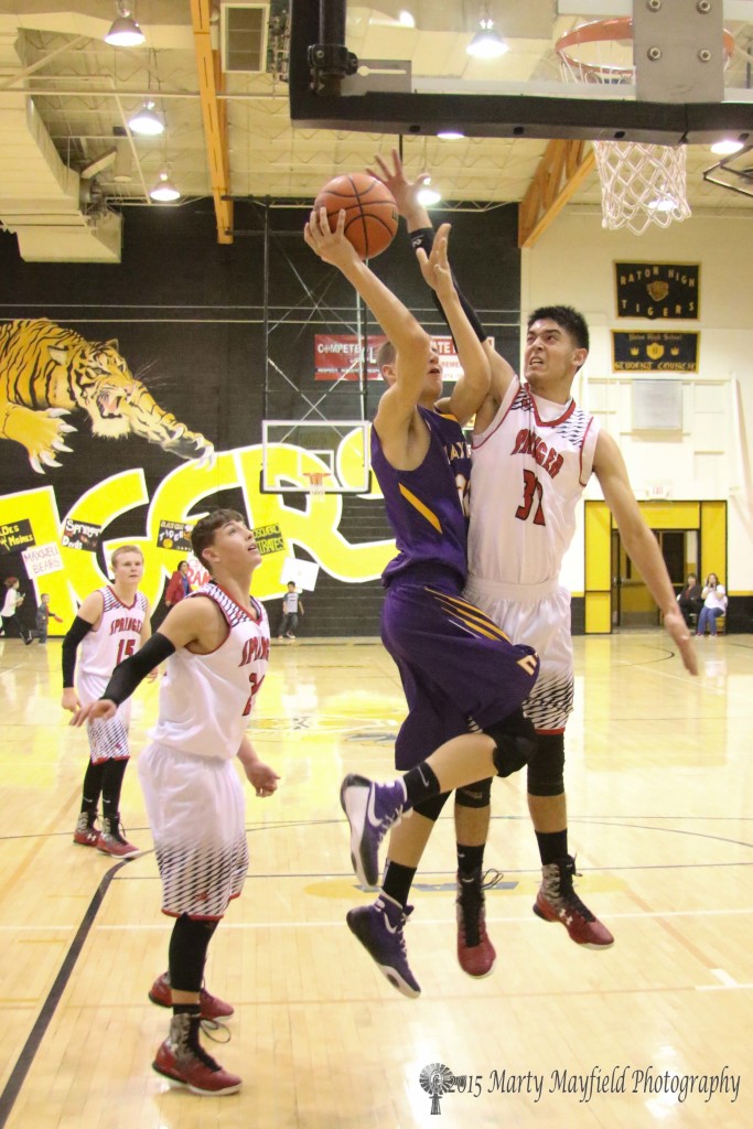 Zac Caldwell goes for the block as Kolten Riggs works for the lay-up Monday evening during the boys championship game of the 2015 Cowbell