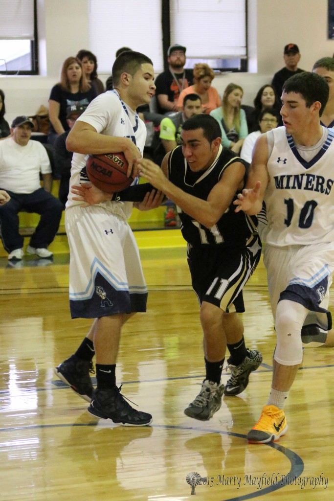 Raton’s Dustin Segura (11) was headed for the basket but Michael Quintana grabs the ball as Tanner Smith (10) squeezes Segura forcing the turnover.
