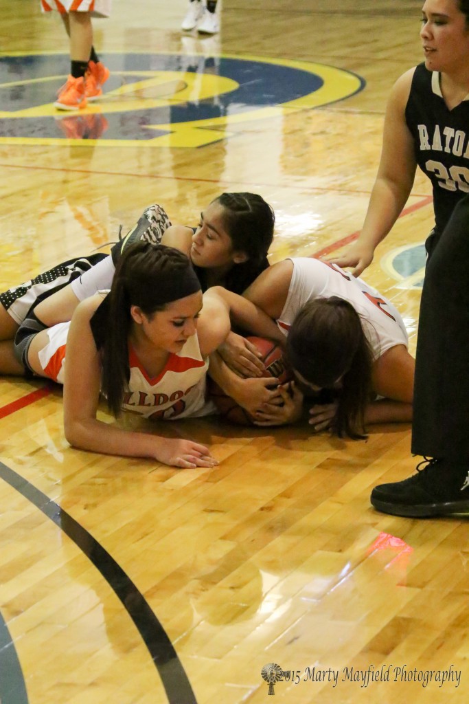 its a mad scramble for the ball as Lady Bulldogs Madison Dasko and Taylor Mestas try to wrap up the ball as Autumn Archuleta and Sydni Silva loose out on the scramble Thursday morning at the TSJC Tourney in Scott Gym.