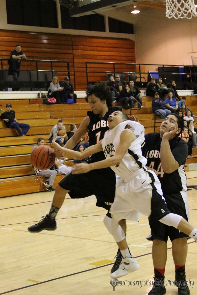 Anthony Ulibarri goes for the block as Richie Acevedo goes for the lay-up, Isaiah Trujillo watches on.