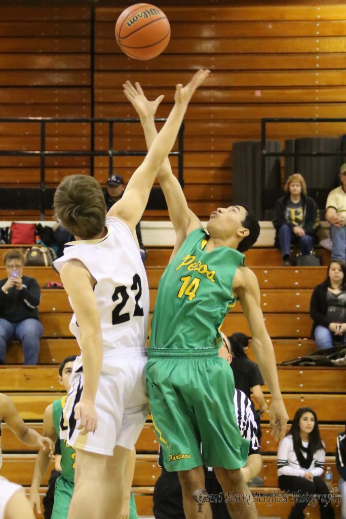 It only takes a fingertip as Dillon Lemons (22) just gets that much higher than Carlos Cordova (14) on the jump ball at the beginning of the game Friday evening.