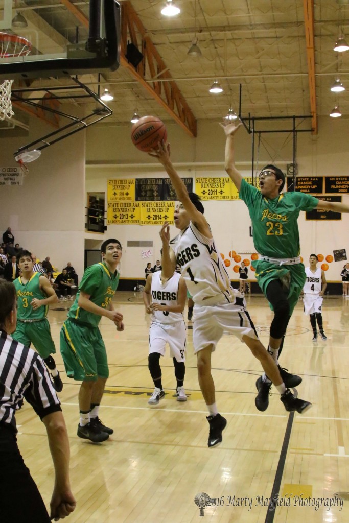 Jesse Espinoza (1) breaks the lane and goes for the shot as Mario Archuleta (23) attempts the block