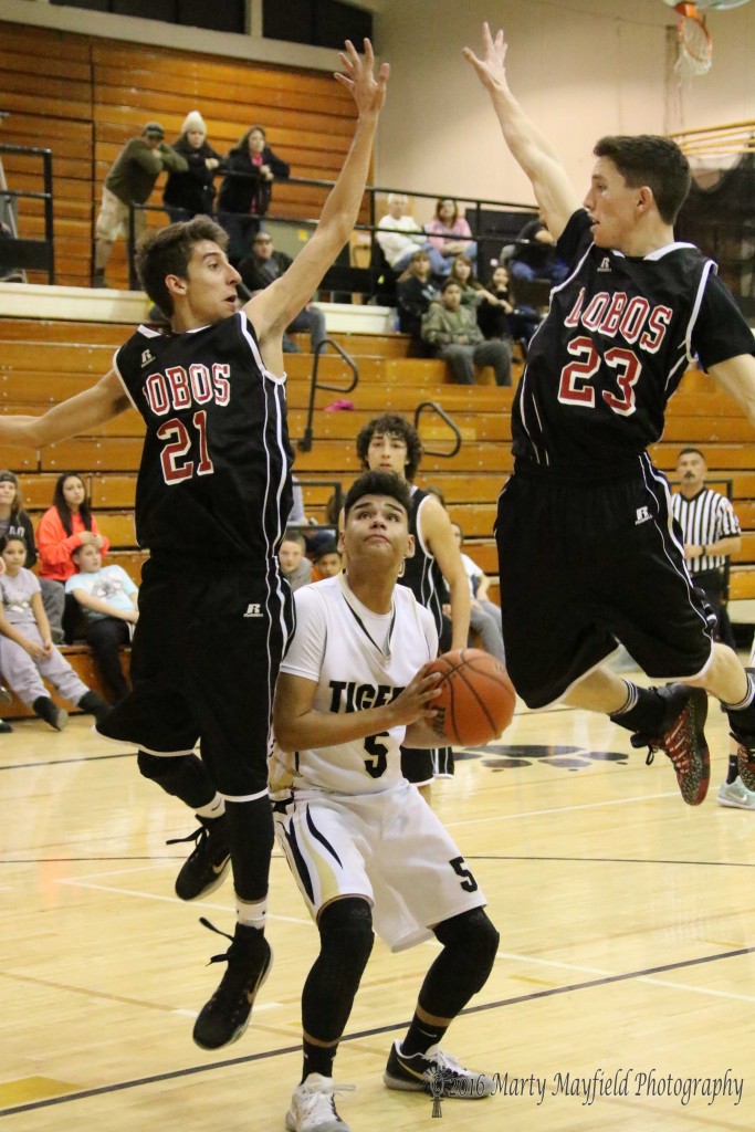 Austin Jones (5) makes the fake work as Aaron Rendon (21) and Tristen Martinez (23) go up for a block.