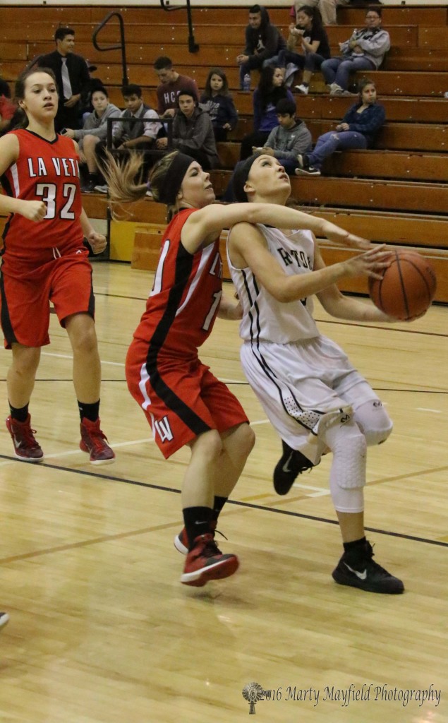 Ashley McCay reaches over Estrell Vargas as she heads in for a shot.