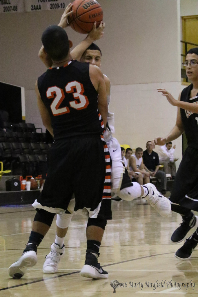 Fransisco Ortiz (23) gets set as Richie Acevedo goes for the basket, Acevedo draws the charging foul 