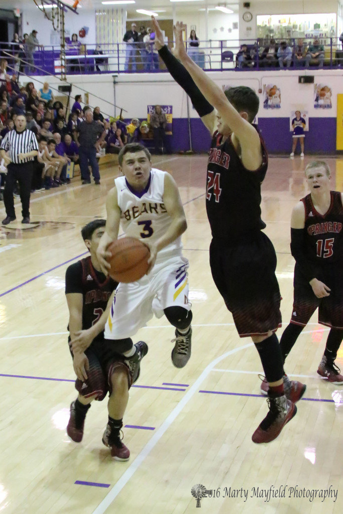 Jeremy Archuleta (3) squeezes in under Isaiah Garcia (24) on his way to the basket 